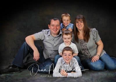 Smilling, happy family portrait of five in casual attire.