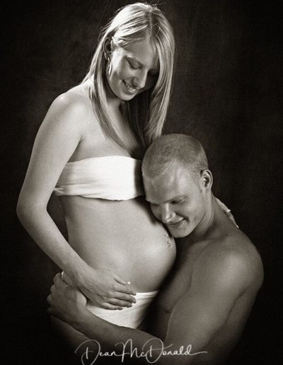 Maternity portrait of a father listening to mums tummy.