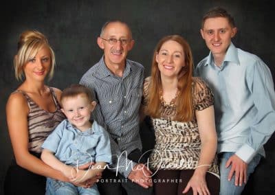 Family Portrait of grandparents, parents and child.