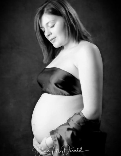 Maternity Portrait of a womans tummy draped in a black silk sheet.
