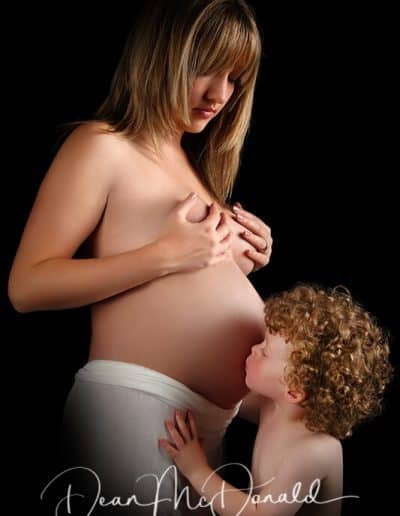 Maternity Portraits young son kissing mums tummy.