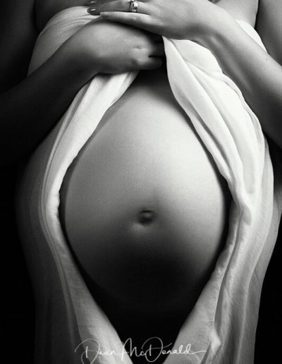 A maternity portrait showing an 8-month pregnant woman's belly.