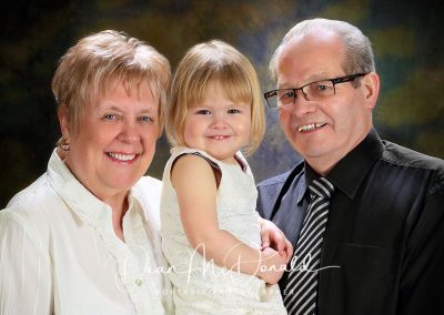 A smiling family portrait posing together.