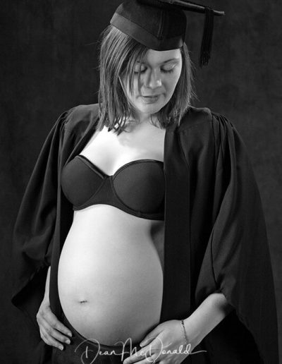 Pregnant woman in graduation attire.