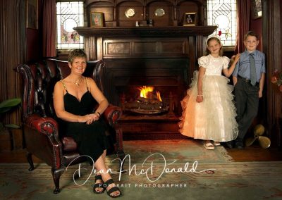 A family portrait at home with a log fire.