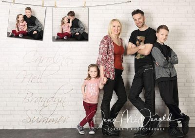 Studio family portrait, against a white brick wall with creative extra images.