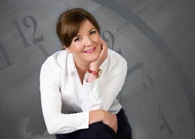 Woman in white shirt, thoughtful Business pose. Clock, Time landscape background | Dean McDonald Photography