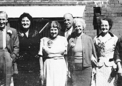 Old photo in need of restoring. Group photo in vintage attire.