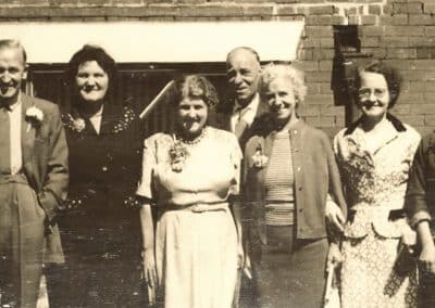 Old sepia photograph in need of restoring. Group photo in vintage attire.