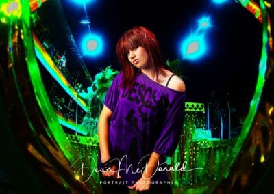 Vibrant studio portrait of a teenager with a striking colour backdrop.