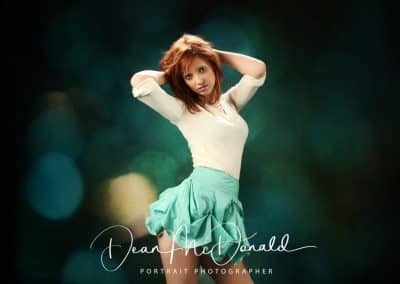 A young woman in a cream top and green rara skirt.
