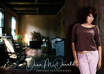 A brunette teenager leaning against a door.