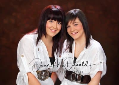 Teenage sisters in white jackets and large fancy belts.