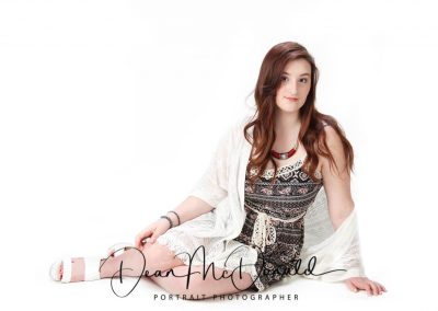 A teenager in a black knitted dress and white wrap.