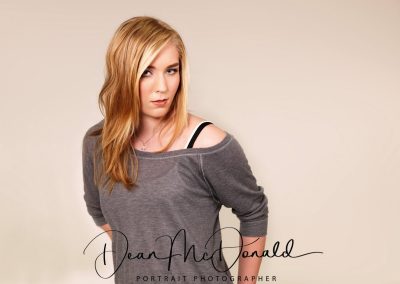 A striking pose of a teenager in a grey top.