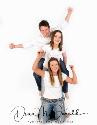 A fun portrait of three teenagers with natural expressions in colour matched outfits.