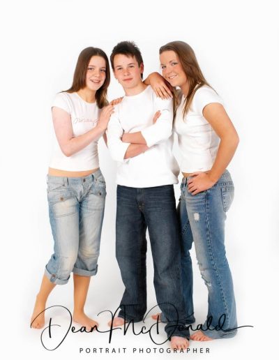 Three teenagers with natural expressions colour matched outfits.