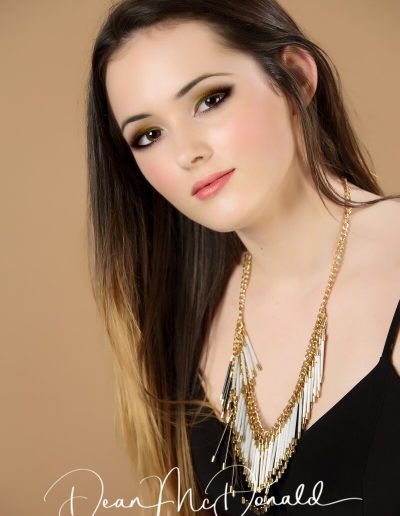 Elegant woman with long hair wearing statement necklace and a black dress.