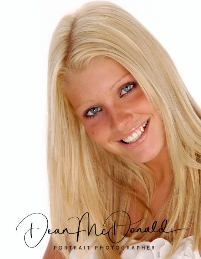 Teenager portrait with Long blonde hair, soft lighting and a white top.