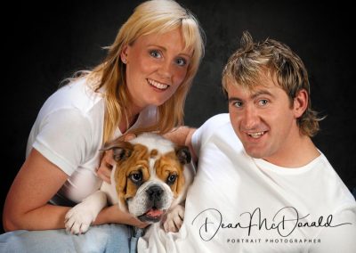 Couple holding an adorable bulldog.
