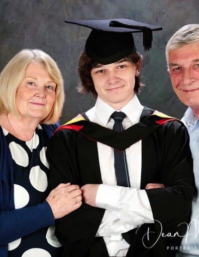 Proud graduate with supportive family members.