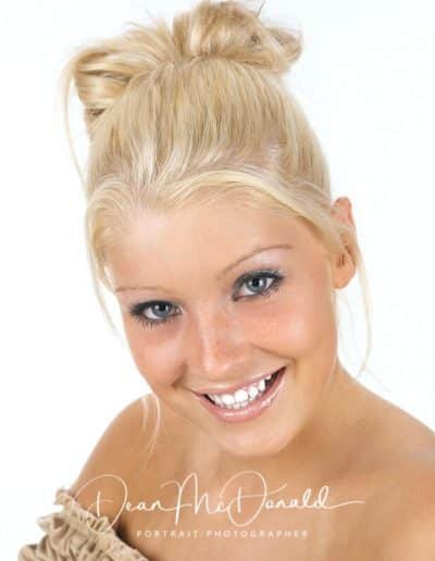 Teenager with blonde hair styled in a bun. Headshot portrait