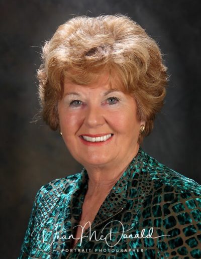 Elegant woman in green patterned blouse.