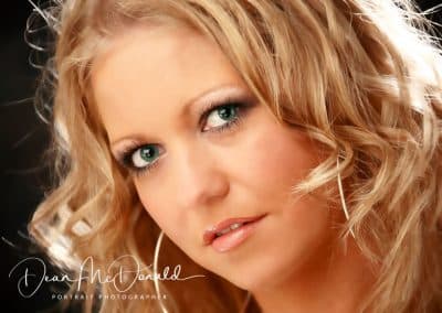 Teenager with soft curls framing a serene expression.