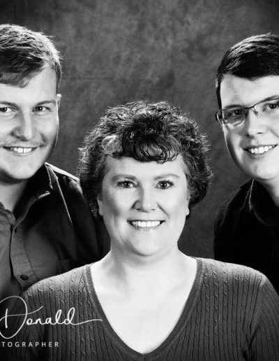 Monochrome portrait of three people posing for a portrait.